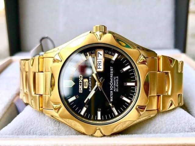 Digi Bear Seiko 5 automatic watch with a gold-tone stainless steel case, black dial, and day-date display.