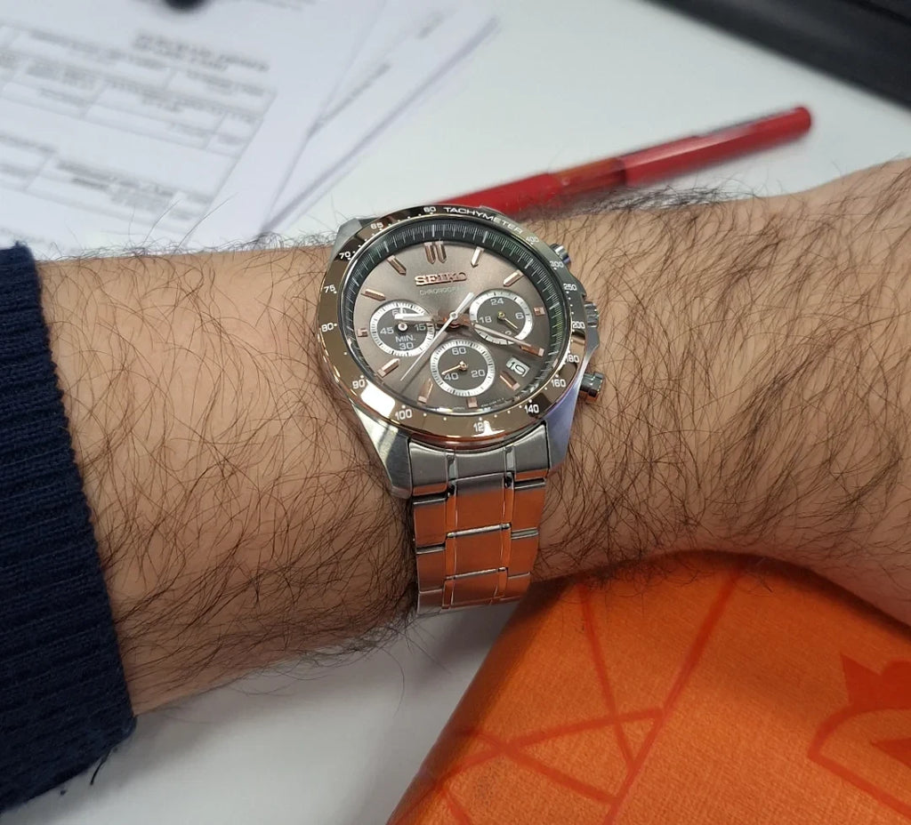 Digi Bear Seiko SBTR026 chronograph watch with a rose gold dial and stainless steel bracelet on a man's wrist
